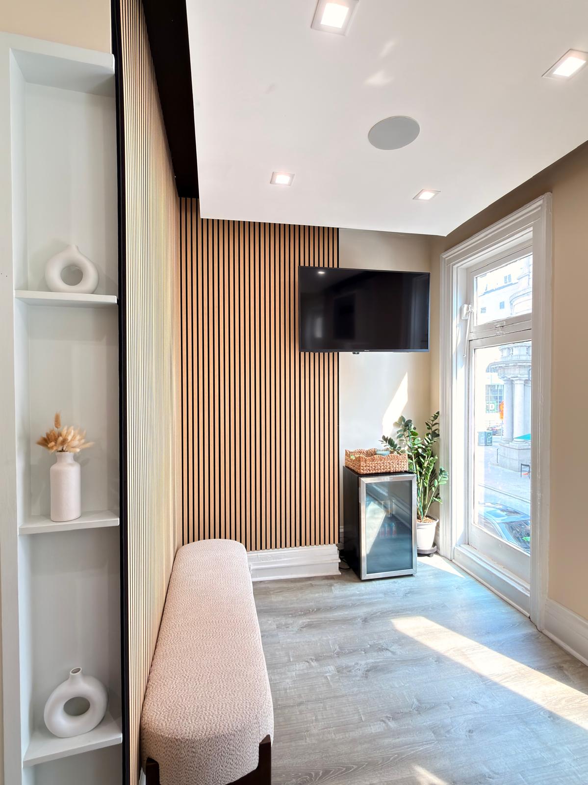 The sunlit Cura Health Collective waiting room with a wood slat wall and bench